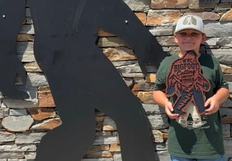 Festivalgoers at a Bigfoot-themed event in Marion, North Carolina, with a young contest winner