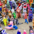A crowd of people in dinosaur costumes celebrating a Guinness World Record in Vernal, Utah